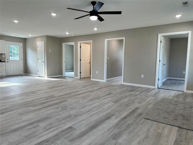 unfurnished living room with light wood-type flooring and ceiling fan