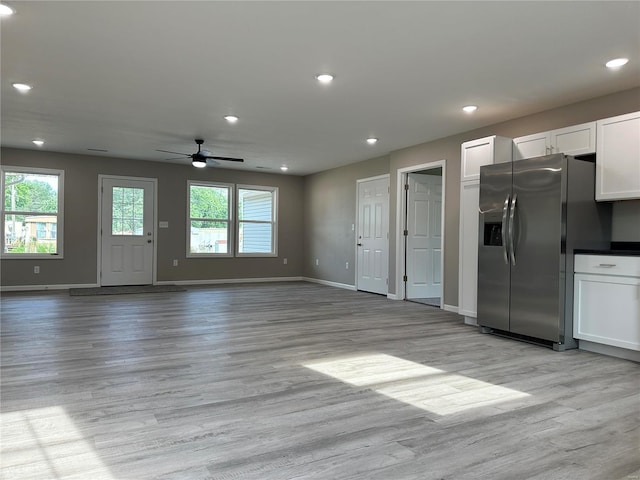 unfurnished living room featuring ceiling fan and light wood-type flooring