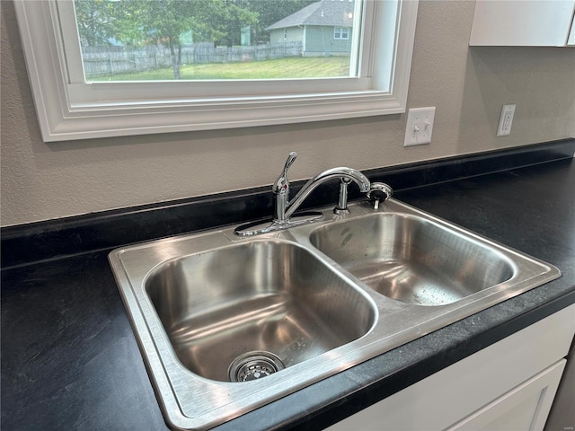 details featuring white cabinets and sink