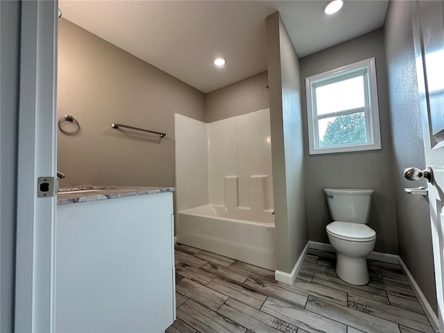 bathroom with wood-type flooring, bathing tub / shower combination, and toilet