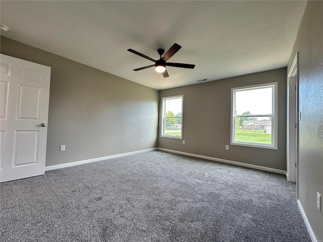 carpeted spare room with a textured ceiling and ceiling fan