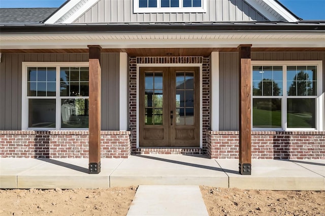 view of exterior entry with covered porch and french doors