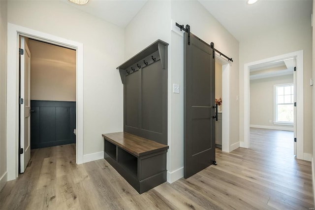 mudroom featuring a barn door and light hardwood / wood-style flooring