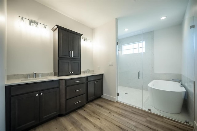 bathroom featuring hardwood / wood-style flooring, vanity, and separate shower and tub