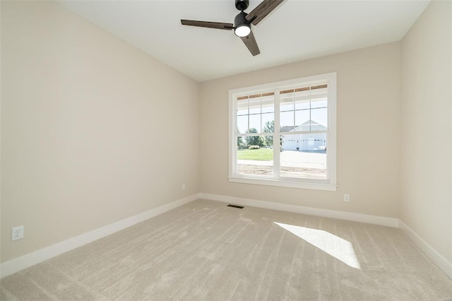 carpeted spare room featuring ceiling fan