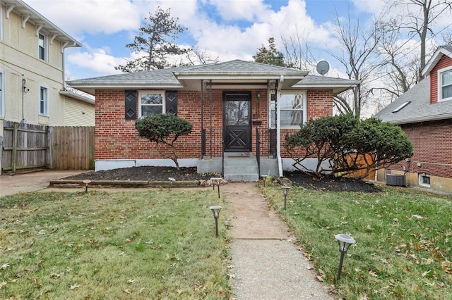 bungalow with cooling unit and a front yard