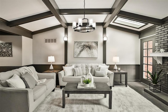 living room featuring wood-type flooring, vaulted ceiling, and an inviting chandelier