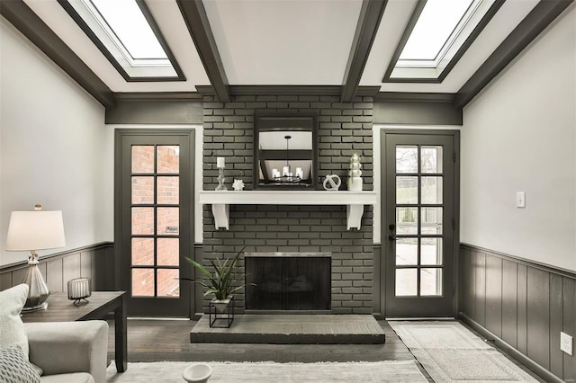 living room featuring beamed ceiling, hardwood / wood-style floors, and a fireplace