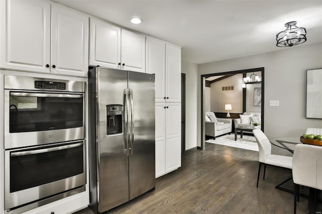 kitchen with white cabinetry, stainless steel appliances, and dark wood-type flooring