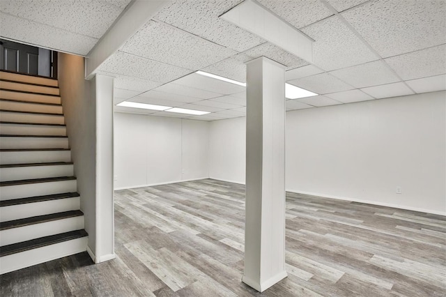 basement featuring a drop ceiling and wood-type flooring