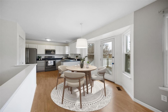 dining space with light wood-type flooring and sink