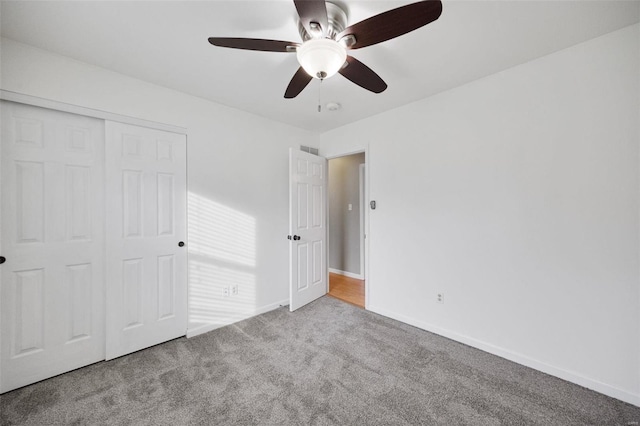 unfurnished bedroom with light carpet, a closet, and ceiling fan