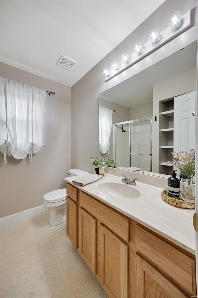 bathroom featuring vanity, toilet, and a shower with door