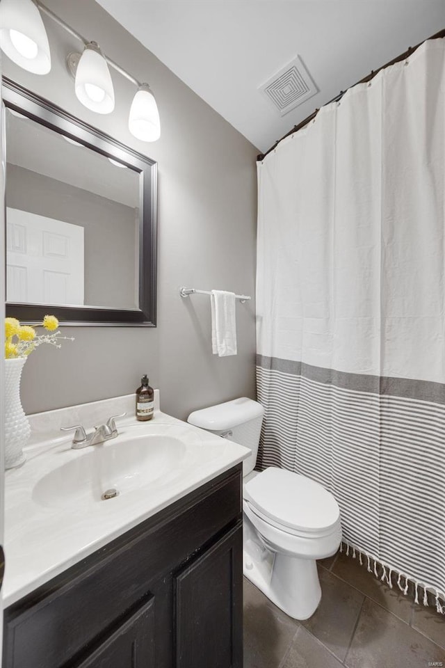 bathroom with tile patterned flooring, vanity, and toilet