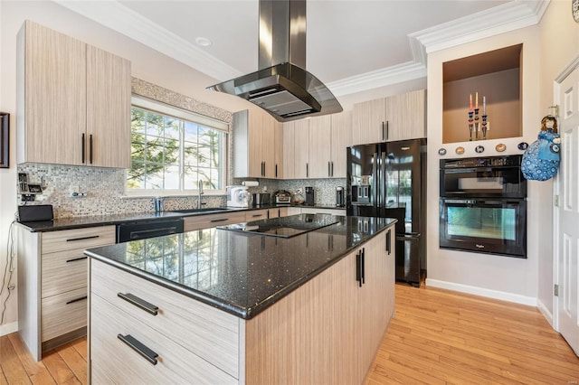 kitchen featuring a kitchen island, sink, dark stone counters, island exhaust hood, and black appliances