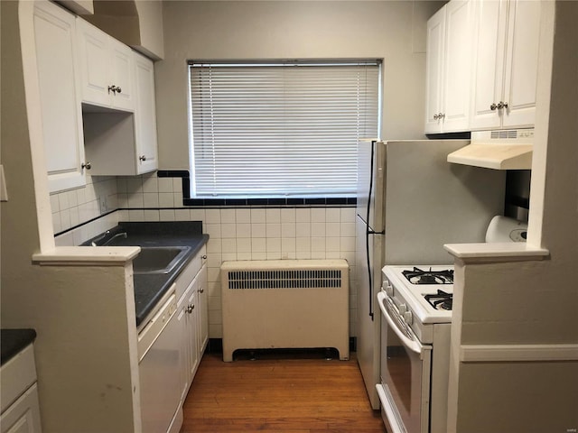 kitchen featuring radiator, white cabinetry, sink, dark wood-type flooring, and white appliances