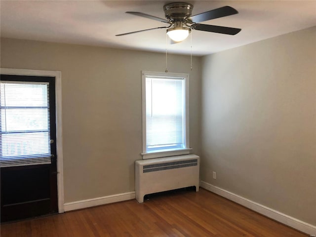 unfurnished room featuring hardwood / wood-style floors, radiator, and ceiling fan