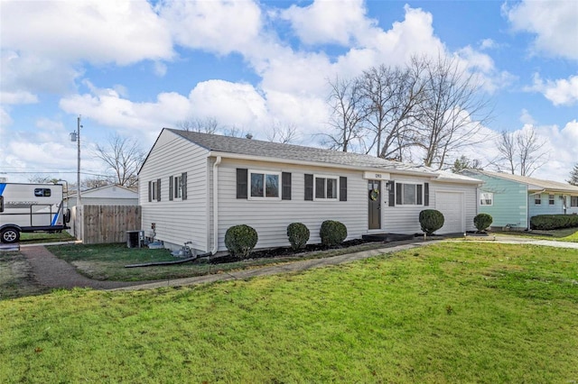 ranch-style home featuring a garage, central air condition unit, and a front lawn