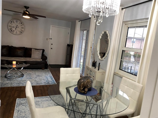 dining space with ceiling fan with notable chandelier and dark wood-type flooring