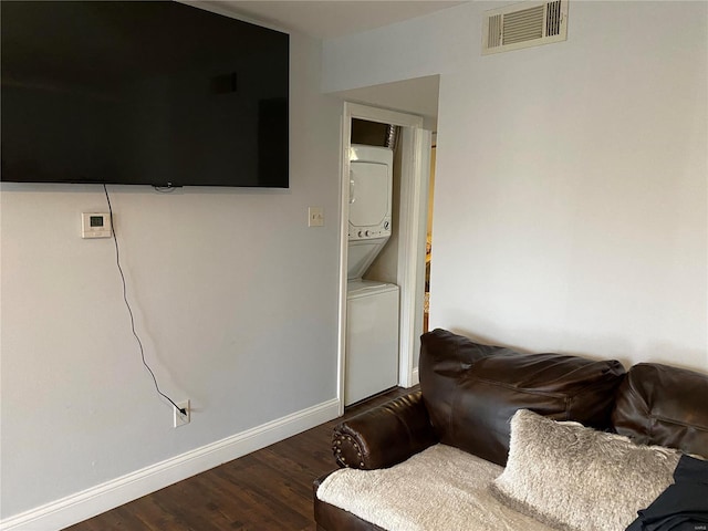 living room featuring dark hardwood / wood-style floors and stacked washing maching and dryer