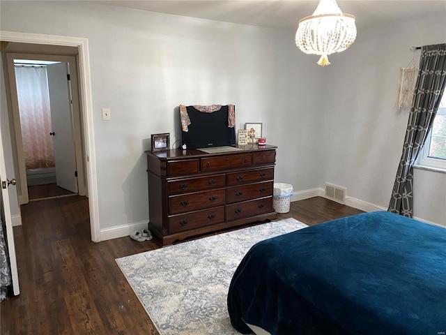 bedroom with dark hardwood / wood-style flooring and a notable chandelier