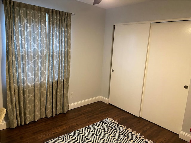 unfurnished bedroom featuring a closet and dark wood-type flooring