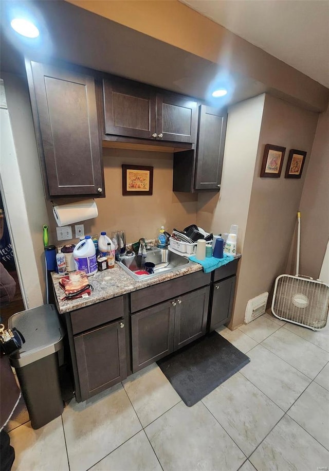 kitchen with light tile patterned flooring, sink, and dark brown cabinets