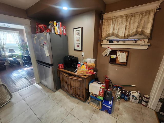 kitchen with light tile patterned floors and stainless steel refrigerator