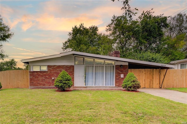 view of front of house featuring a carport and a yard