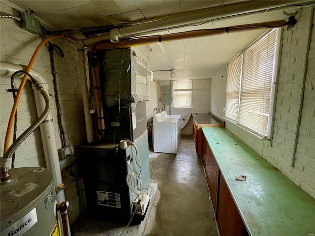 basement featuring washing machine and dryer, electric panel, and water heater