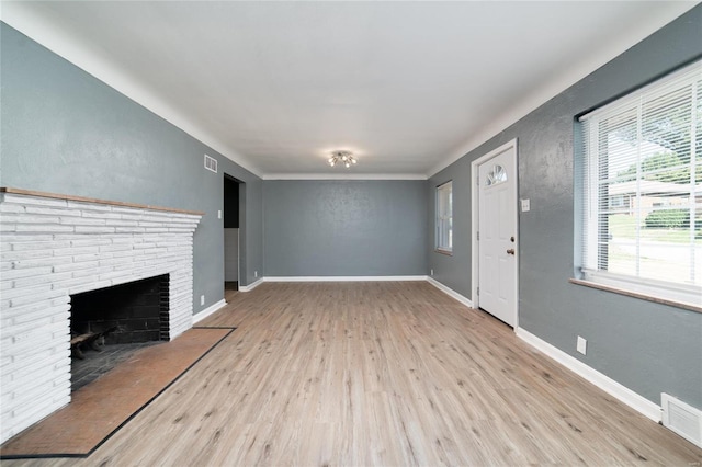 unfurnished living room with a brick fireplace and light wood-type flooring