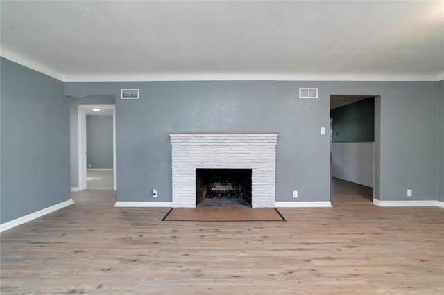 unfurnished living room with a fireplace and light hardwood / wood-style flooring