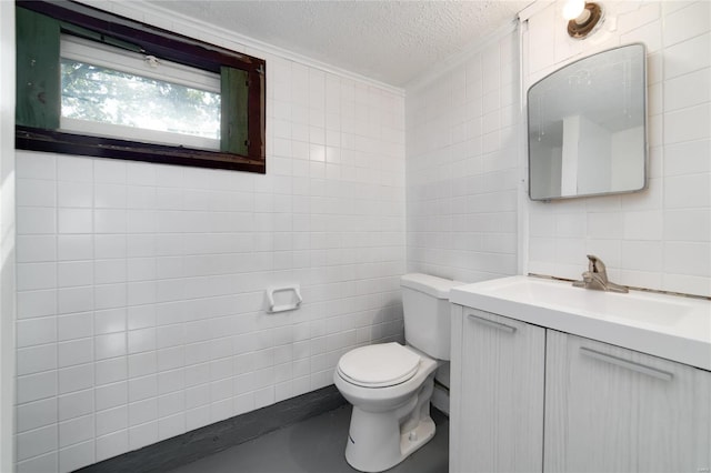 bathroom with tile walls, vanity, a textured ceiling, and toilet