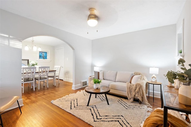 living room with an inviting chandelier and light hardwood / wood-style flooring