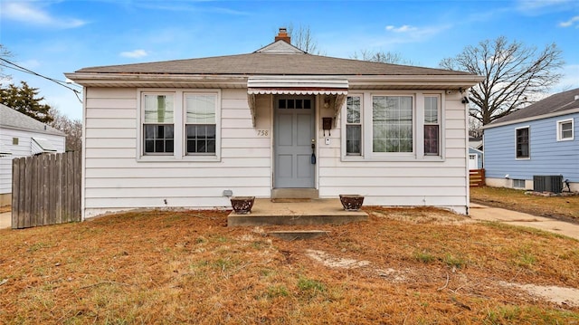 bungalow-style house with cooling unit and a front yard