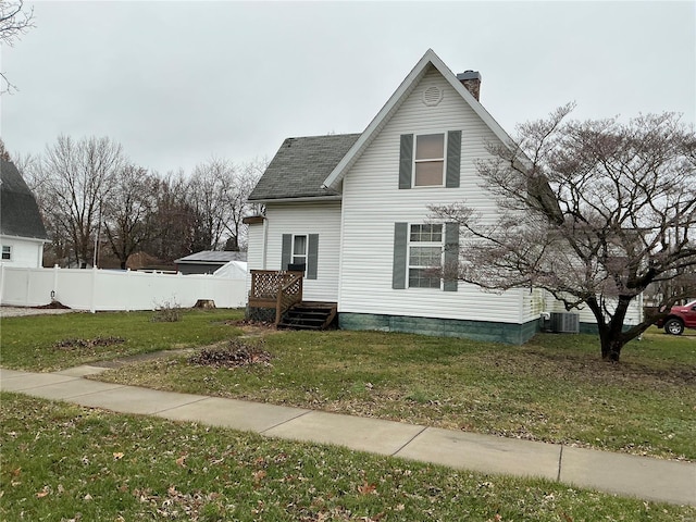 view of front of house with a front yard and central AC unit