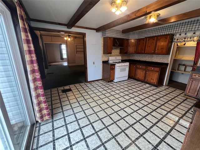 kitchen featuring ceiling fan, beam ceiling, backsplash, and gas range gas stove