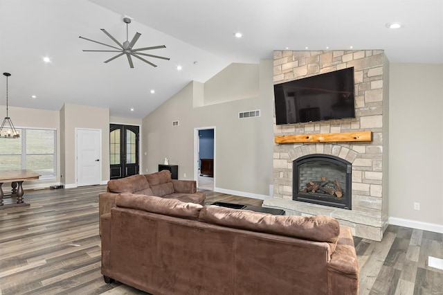 living room featuring hardwood / wood-style floors, ceiling fan, a fireplace, and high vaulted ceiling