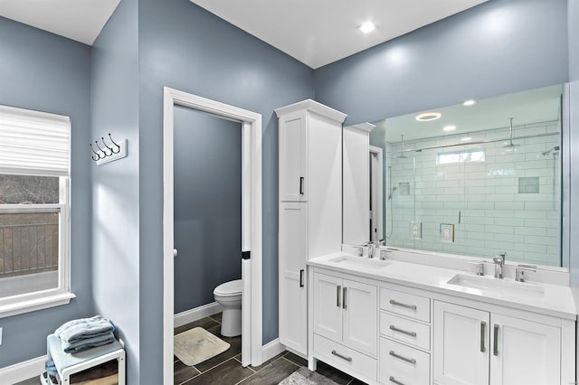 bathroom with hardwood / wood-style floors, toilet, an enclosed shower, and vanity