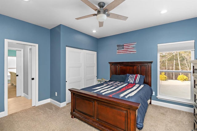 carpeted bedroom featuring ceiling fan and a closet