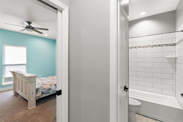 bathroom featuring ceiling fan, toilet, and tiled shower / bath combo