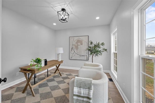 home office featuring a chandelier, dark hardwood / wood-style flooring, and a healthy amount of sunlight