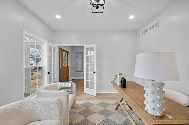 home office featuring french doors, a notable chandelier, and hardwood / wood-style floors