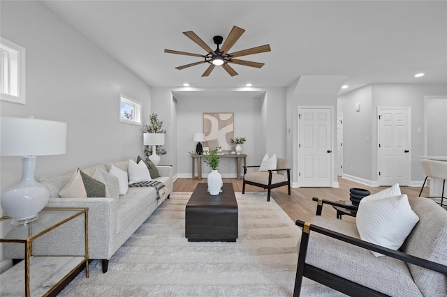 living room featuring light wood-type flooring and ceiling fan