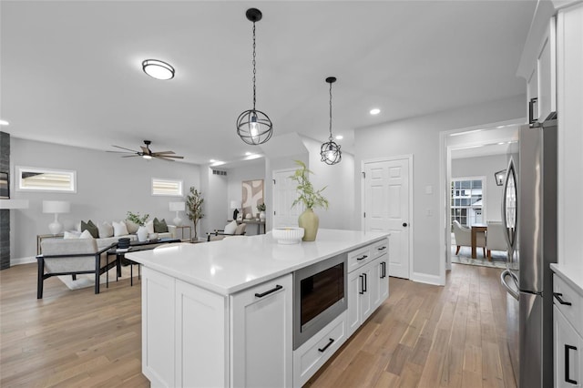 kitchen featuring appliances with stainless steel finishes, white cabinetry, and a kitchen island