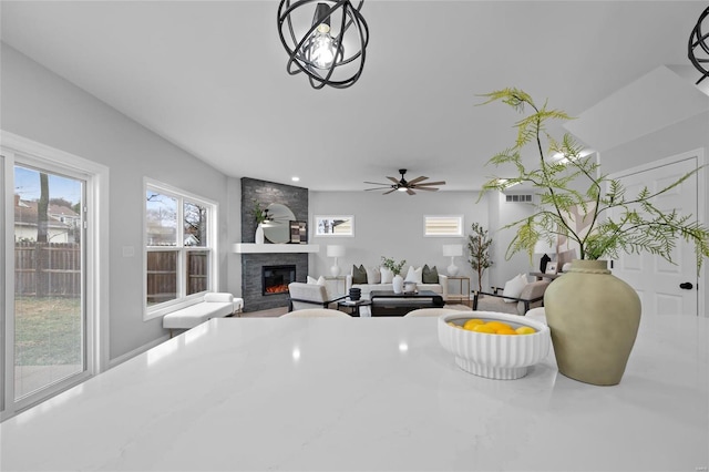 living room with ceiling fan and a fireplace