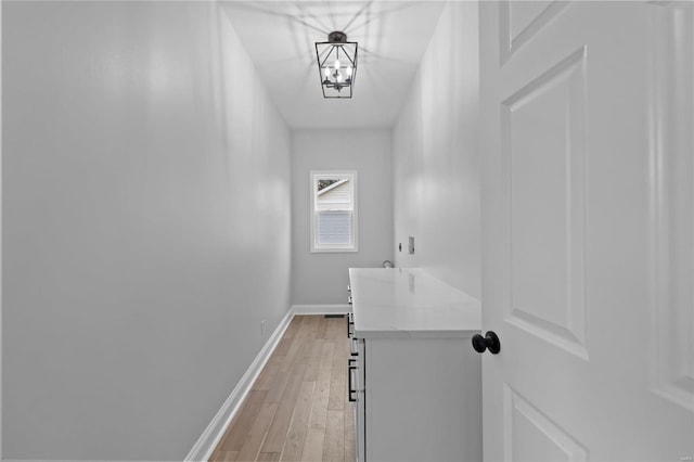 hall with hardwood / wood-style flooring and a chandelier