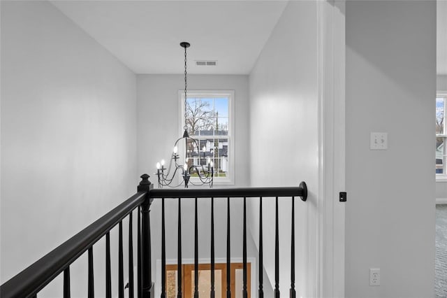 stairway featuring a chandelier