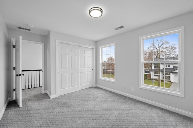 unfurnished bedroom featuring light colored carpet and a closet