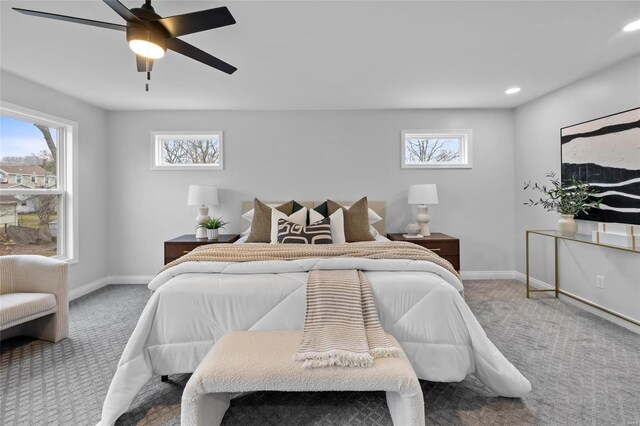 bedroom featuring carpet flooring, ceiling fan, and multiple windows